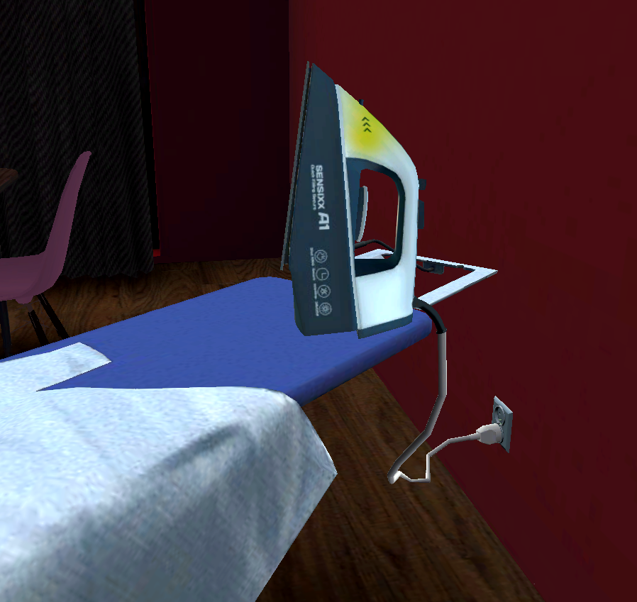 Wpięte do kontaktu żelazko, leżące na desce do prasowania i pozostawione bez nadzoru.