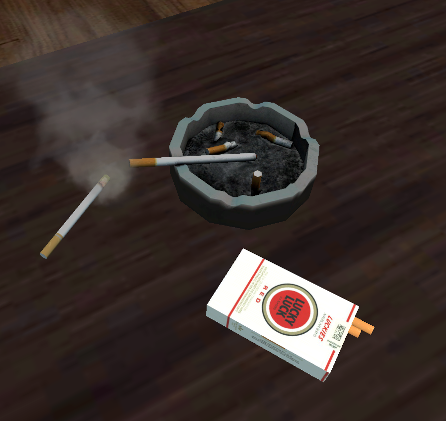 Niedogaszone papierosy w popielniczce i pudełko papieros&oacute;w obok.